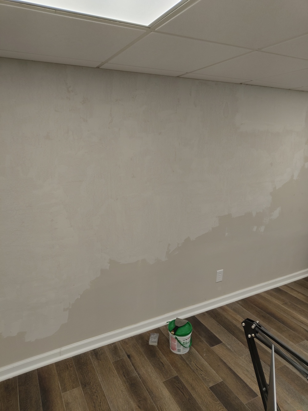 A picture of my home office wall with joint compound all over the wall. It covers most of the wall due to my naturally textured walls.